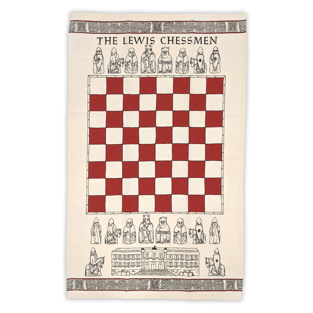 A cream tea towel. In the middle of the towel there is a red and cream chess board design above and below the chess board are line illustrations of the Lewis chessmen. Above the top row of Lewis chessmen are the words "The Lewis Chessmen" and underneath the bottom row is a line illustration of the National Museum of Scotland flanked either side by line illustrations of knight Lewis Chessmen. The top and bottom edge of the towel are decorated with a row of knot work designs.