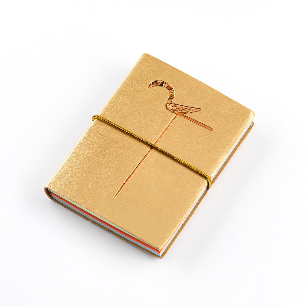 A small gold imitation leather bound notebook with a gold embossed design of a bird pin from the Galloway hoard, coloured pages and an elastic strap.