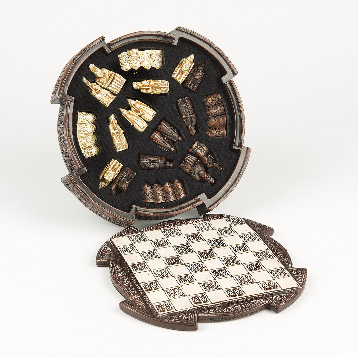 An upright rounded brown resin box, inside a foam insert which houses a brown and a white set of Lewis chess pieces. In front of the box lays a round resin lid with a chess board incorporated. The box and the lid are both decorated with knot work patterns.