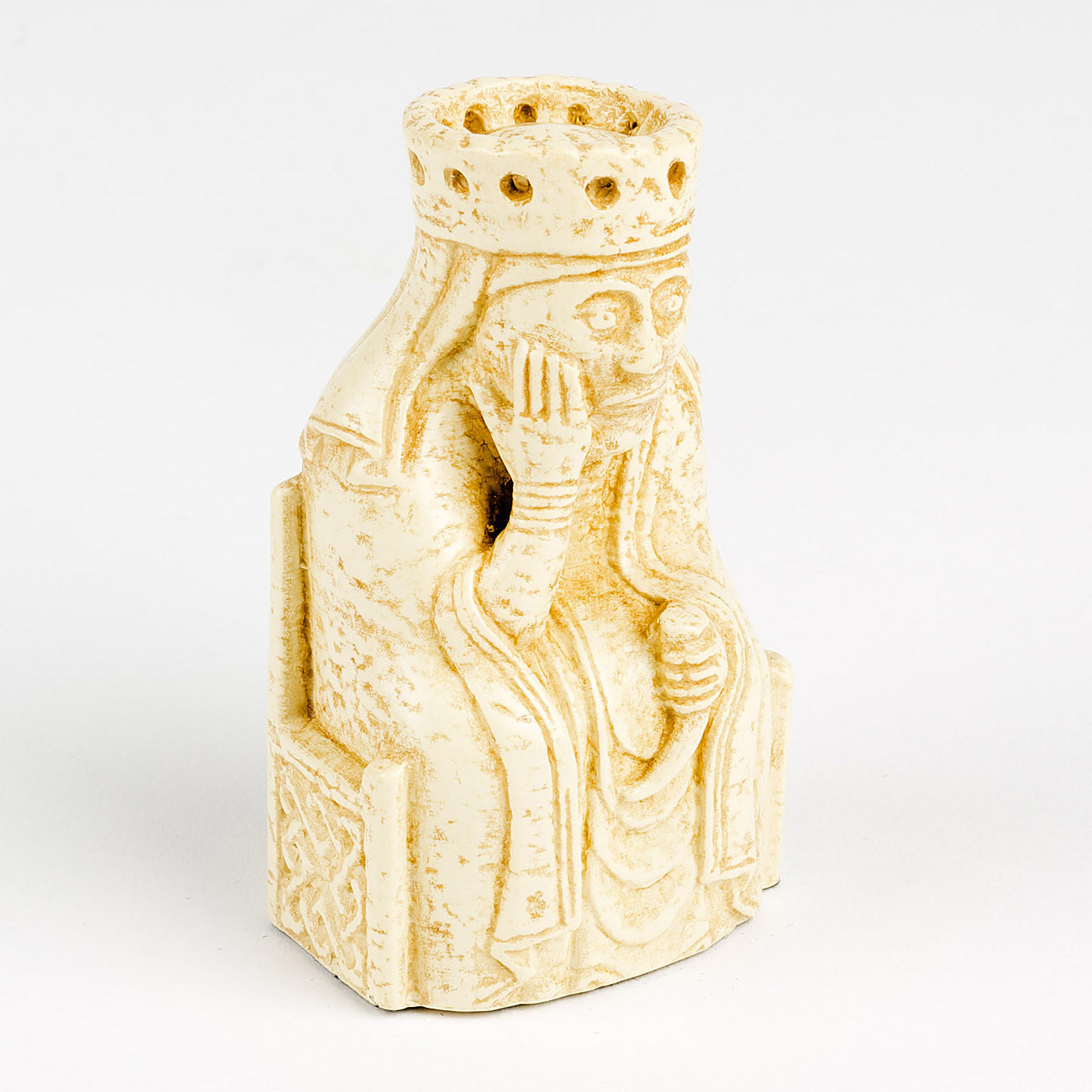 A resin replica of a queen Lewis chess piece. The queen is wearing long robes and a crown, and is sitting on a throne decorated with knot work. She has her chin resting in her right hand and is holding a drinking horn in her left.