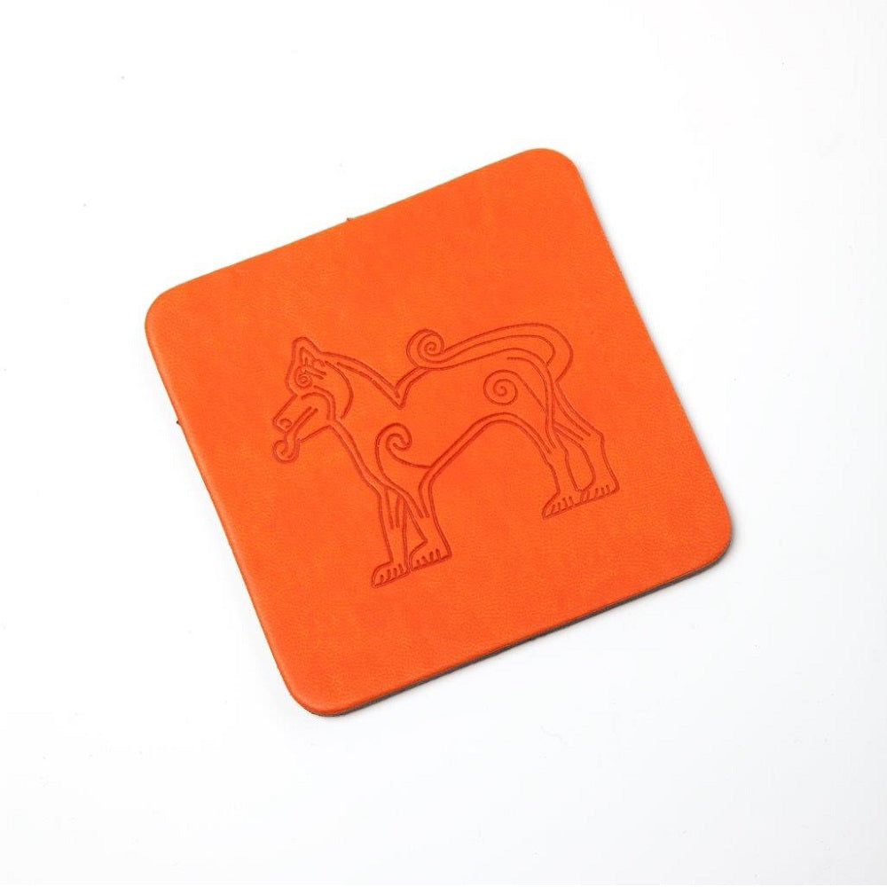 A square orange leather coaster with a design of a lion taken from Pictish carvings embossed on it.