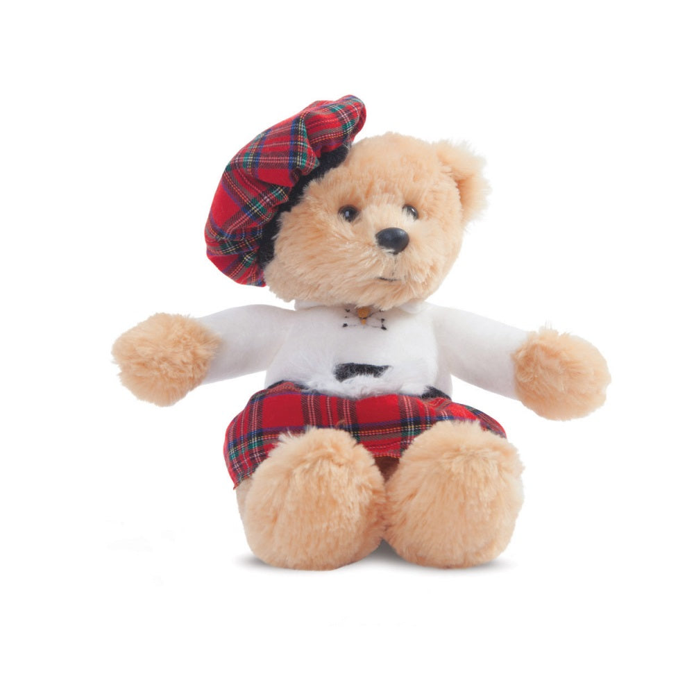 A pale brown teddy bear wearing a red tartan kilt and bonnet and white shirt against a plain white background.