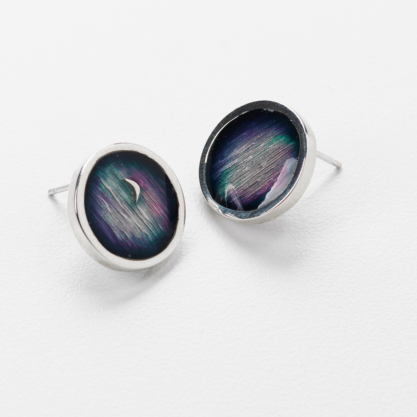 Two round sterling silver stud earrings with a blue and purple colour with an outer silver ring.