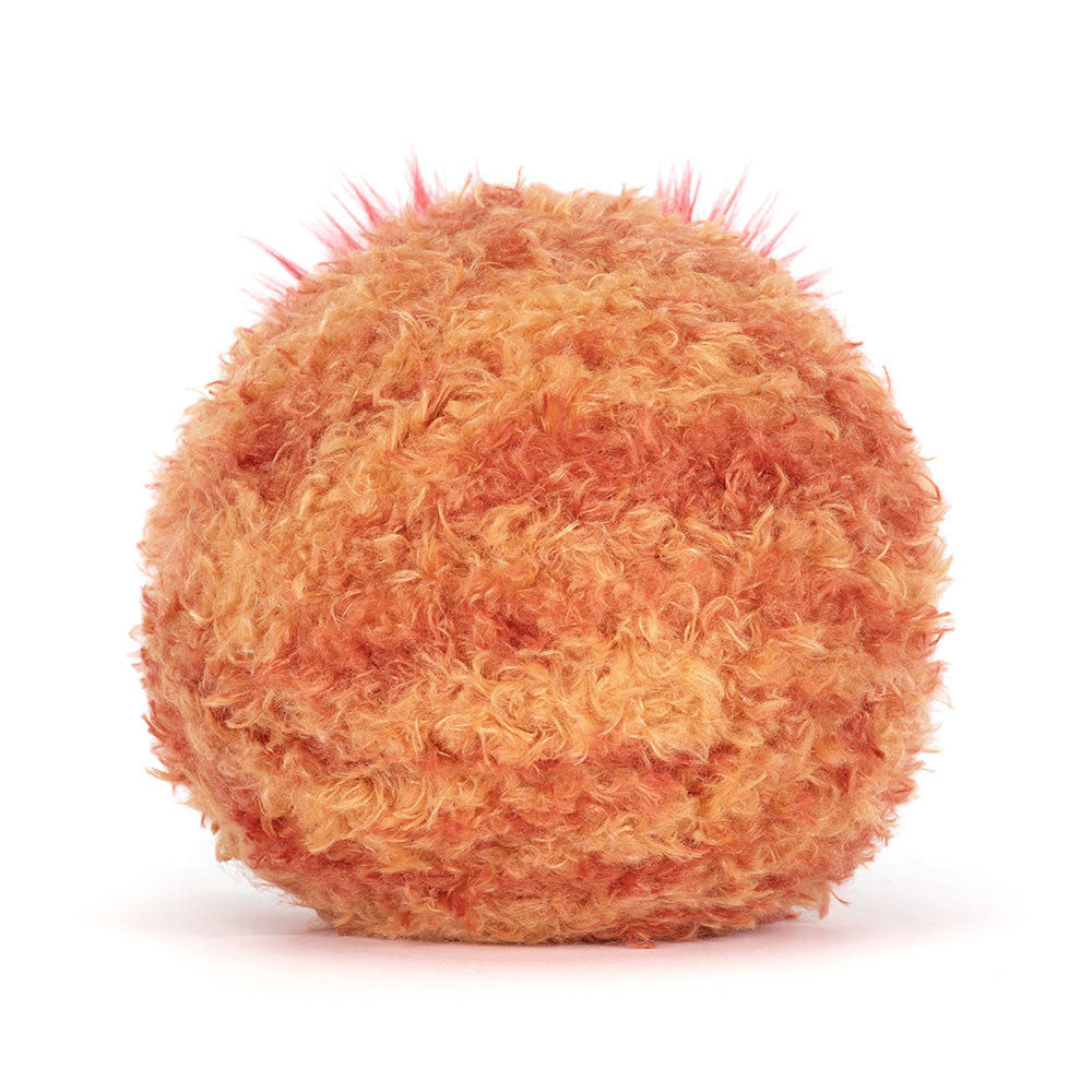 Back view of a soft toy planet mars with a frowning face and large red fluffy eyebrows and brown legs against a white background.