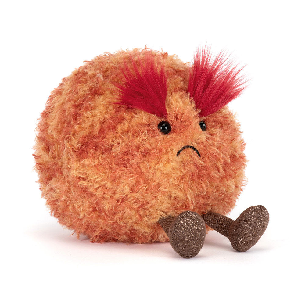 A soft toy planet mars with a frowning face and large red fluffy eyebrows and brown legs against a white background.