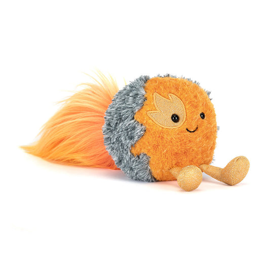 A soft toy of a flaming comet with a smiley face, yellow legs and an orange fluffy trail of faire against a white background.