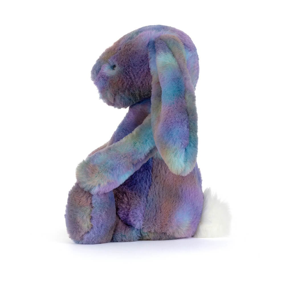 Side view of a multicoloured plush bunny toy in space inspired colours on a white background