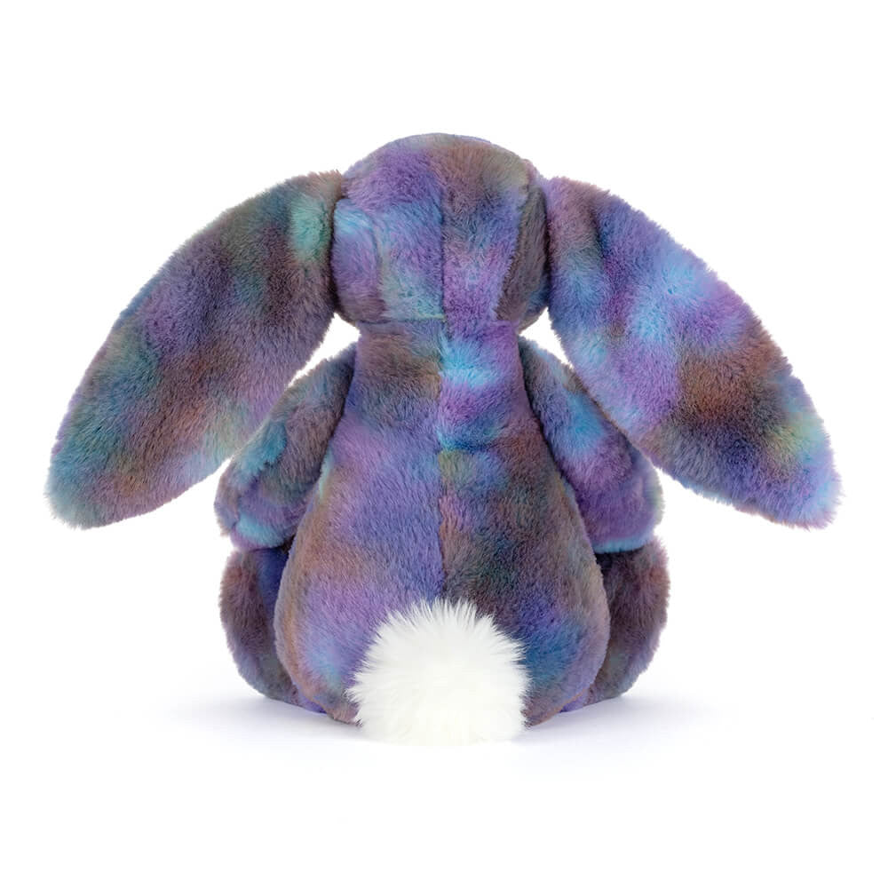 Back view of a multicoloured plush bunny toy in space inspired colours on a white background