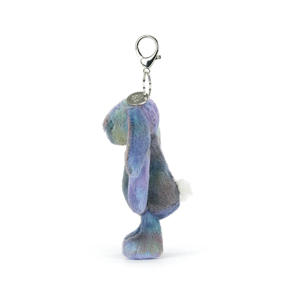 Side view of a plush bunny keychain with pastel space inspired colours on a white background.