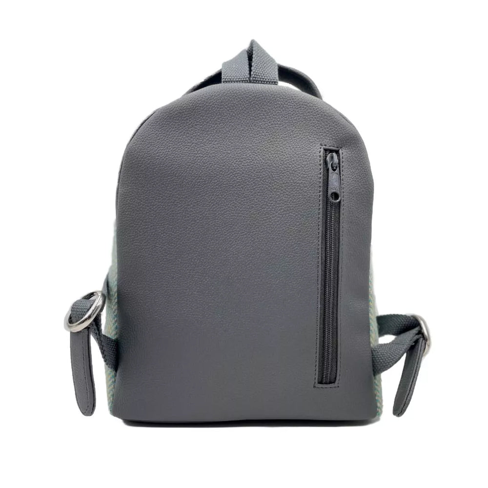 Reverse of backpack showing grey vegan leather backing with canvas straps and a zipped pocket.