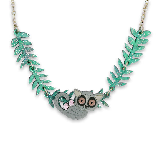 A photograph of an acrylic necklace of a cartoon bush baby hanging from a chain made of acrylic leaves.