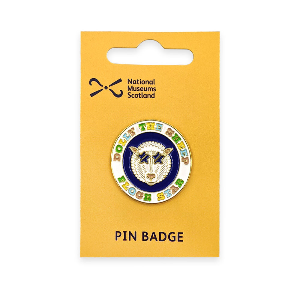 A round enamel pin badge with a colourful design of Dolly the sheep on a yellow backing card against a plain white background.
