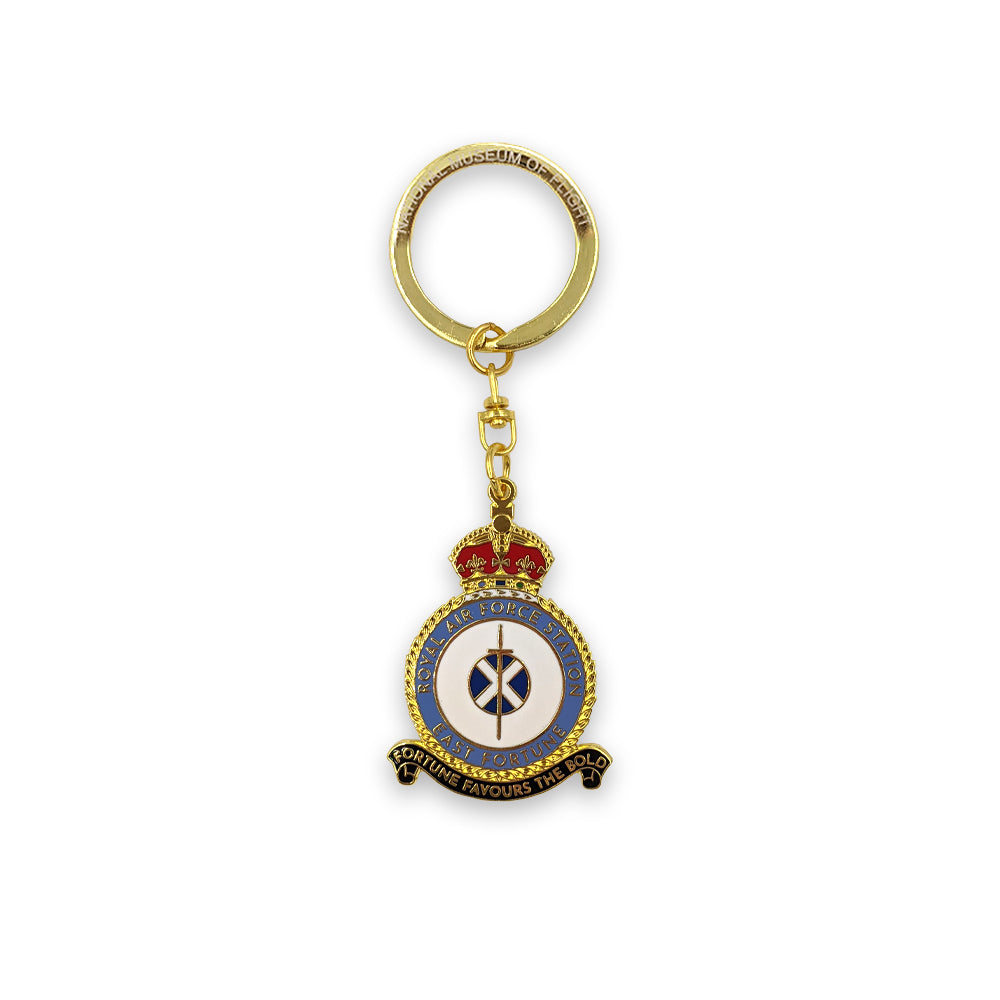 A metal key ring of the East Fortune Royal Air Force badge. A sword lays over a Saltire flag which sits in the centre of a round crest topped by a royal crown.