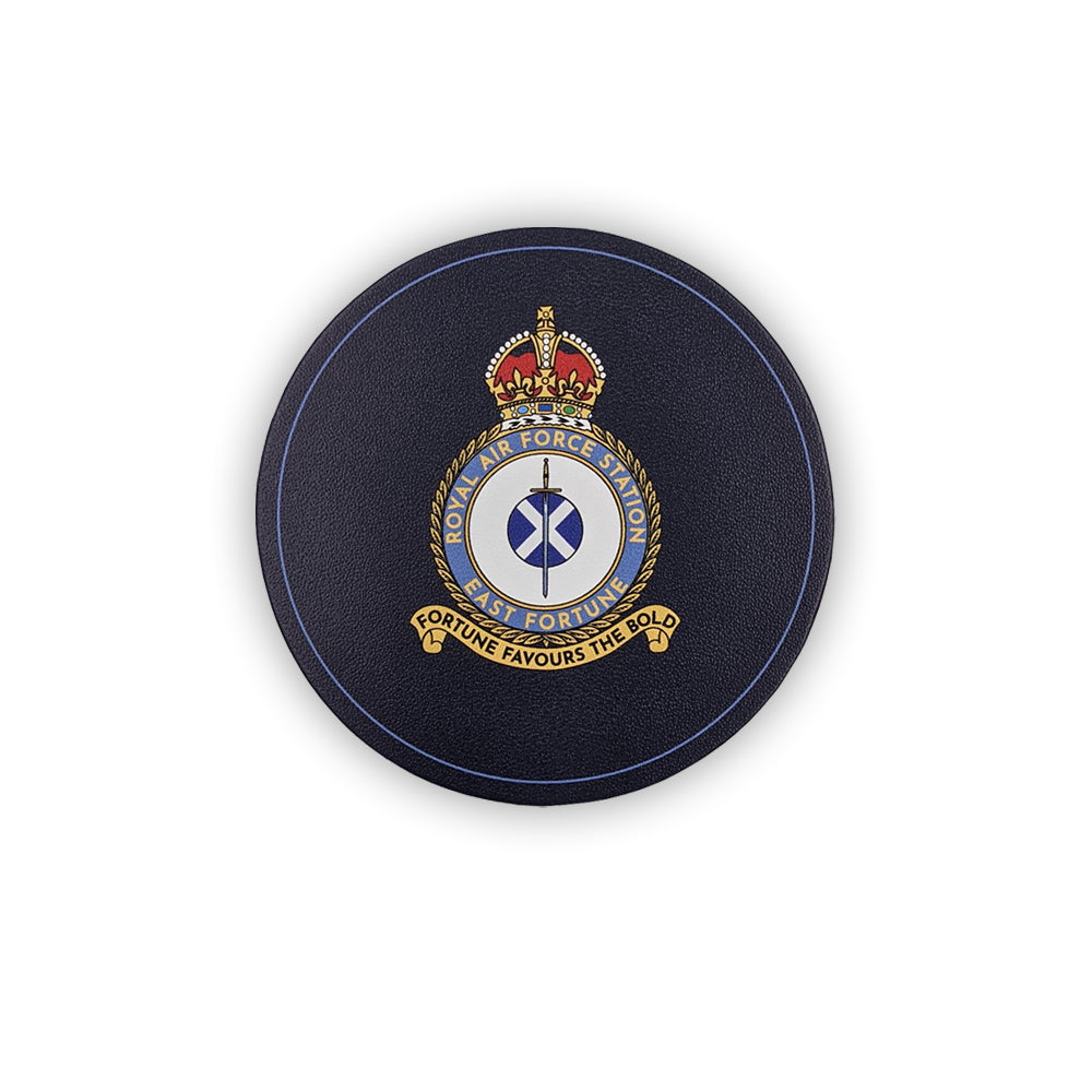 A round navy leather coaster with the East Fortune Royal Air Force badge. A sword lays over a Saltire flag which sits in the centre of a round crest topped by a royal crown.