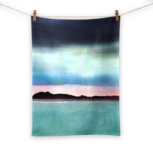 Tea towel with a watercolour painting of Edinburgh's skyline silhouetted over a pink sunset.