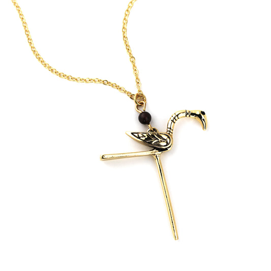 A brass necklace with a small bird charm based on the gold pin found in the Galloway hoard.