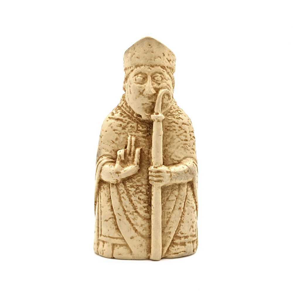 A plastic resin replica magnet of a bishop Lewis chess piece. A bishop in clerical robes holding a crook in his left hand, his right hand raised in prayer.