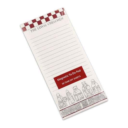 A tall memo pad with a magnet on the back. The very top of the pad has a red chess board pattern with the words "The Lewis Chessmen" underneath. The bottom edge of the pad has a row of knot work designs with illustrations of the Lewis chess pieces above. The majority of the pad is lined.
