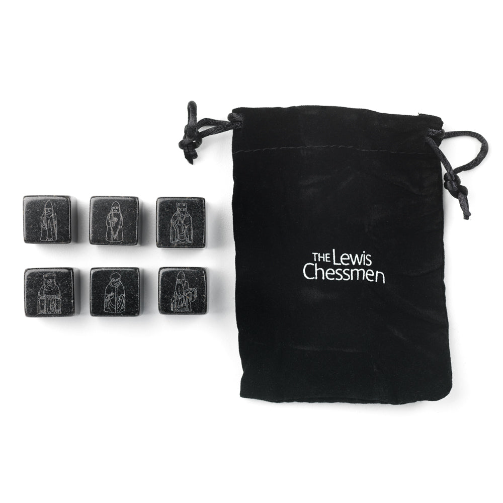A small velveteen drawstring bag with the words "The Lewis Chessmen" printed in white, six small black cubes with images of the Lewis chess pieces etched onto them.