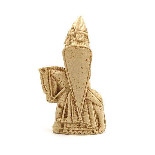 A plastic resin replica magnet of a knight Lewis chess piece. A knight on a horse facing left, the knight is wearing a pointed hat and holding a large body length shield.