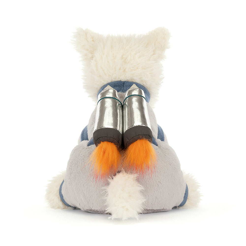 Back view of a plush white Scottie dog in a grey space suit with a shiny silver jetpack with fluffy orange flames against a white background.