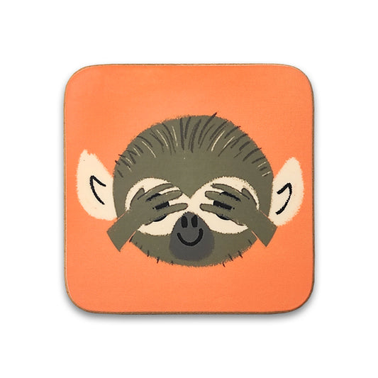 A photograph of an orange square coaster against a plain white background. The coaster is printed with an illustration of a monkey's face with its hands covering its eyes.