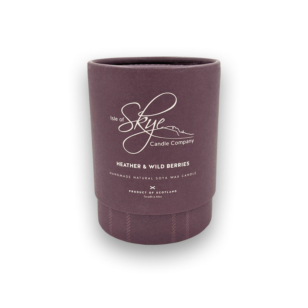 A candle in a round purple box against a plain white background.