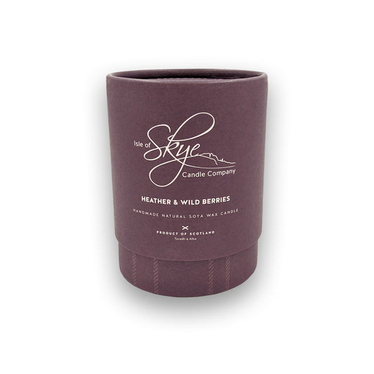 A candle in a round purple box against a plain white background.