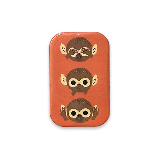 A photograph of an orange rectangular magnet with rounded corners against a plain white background. The magnet is printed with three monkey heads on above the other. The bottom monkey is covering its ears, the middle one is covering its mouth and the top on is covering its eyes.