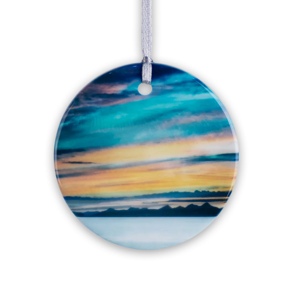 Round porcelain hanging decoration with a watercolour painting of a snurise over Scotland's western isles.