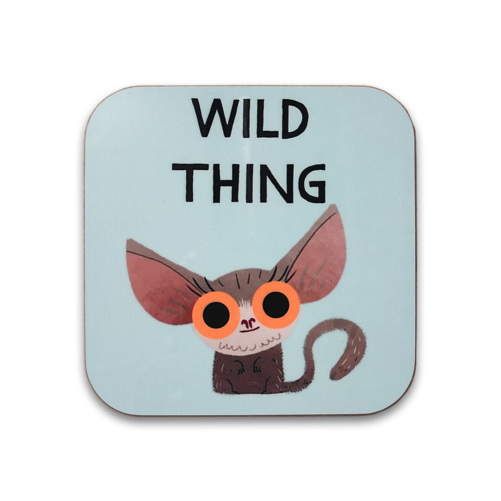 A photograph of a pale blue square coaster against a plain white background. The coaster is printed with an illustration of a bush baby with large orange eyes. Above the bush baby are the words "wild thing".