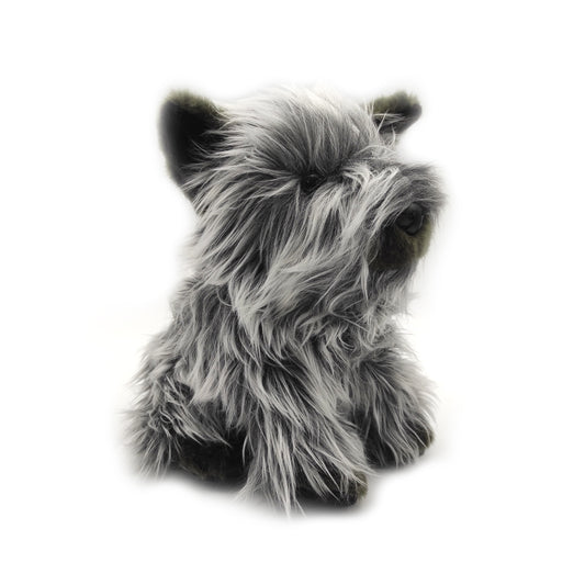 A soft toy Skye terrier with long grey and black fur against a plain white background