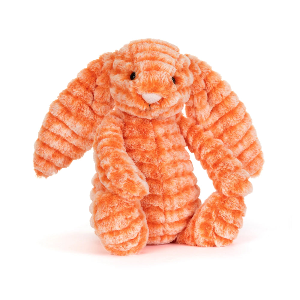 a soft toy bunny with soft ridged orange fur, black plastic eyes, and  a pale pink nose against a plain white background.