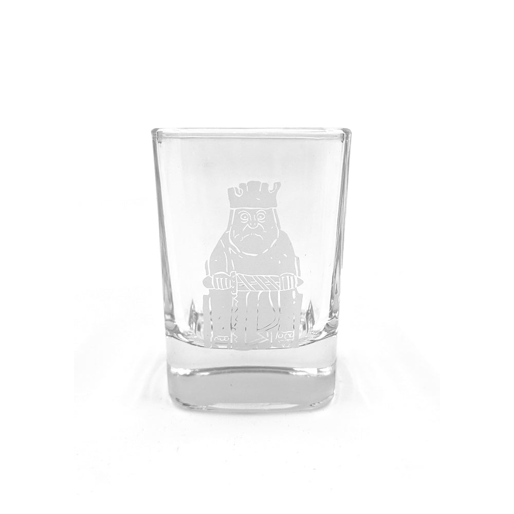 A rounded square shot glass with a printed illustration of a king Lewis chess piece in grey.