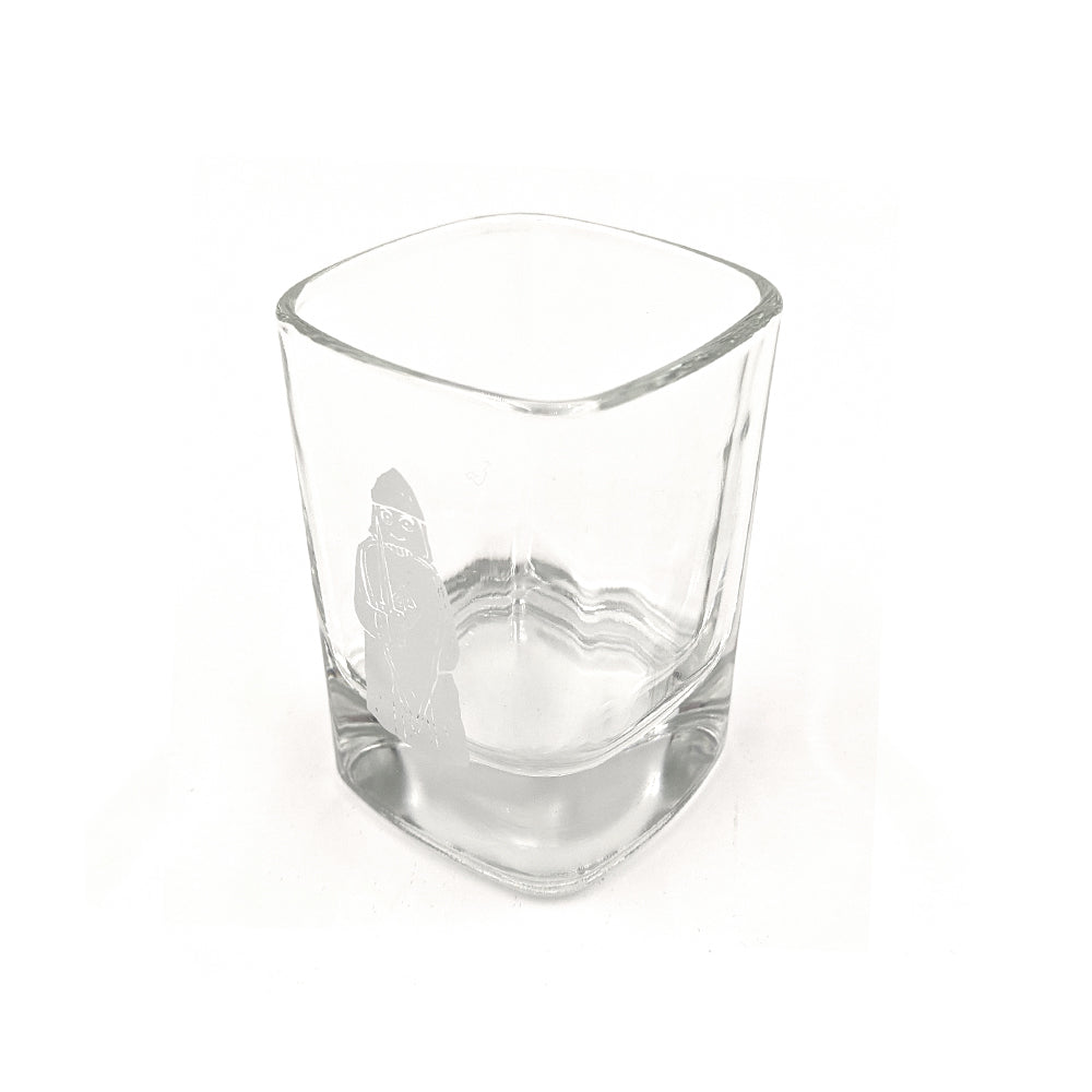 A rounded square shot glass with a printed illustration of a berserker Lewis chess piece in grey.