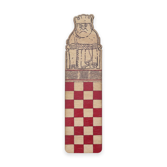 A wooden bookmark with the top half illustrated with a king Lewis chess piece and the bottom half with a red chessboard style grid.
