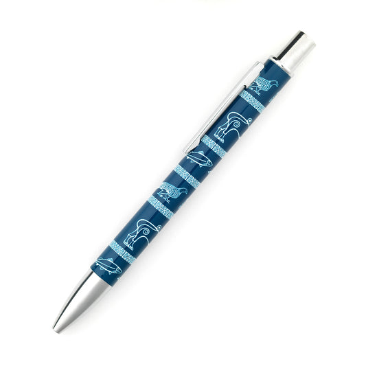 A metal retractable ball point pen with a repeating pattern taken from Pictish carvings of an eagle, a boar, a lion, a fish, and a goose on a blue background. the pen cap, clicker and clip are silver.