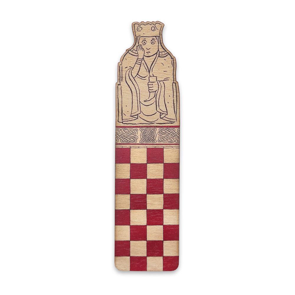 A wooden bookmark with the top half illustrated with a queen Lewis chess piece and the bottom half with a red chessboard style grid.