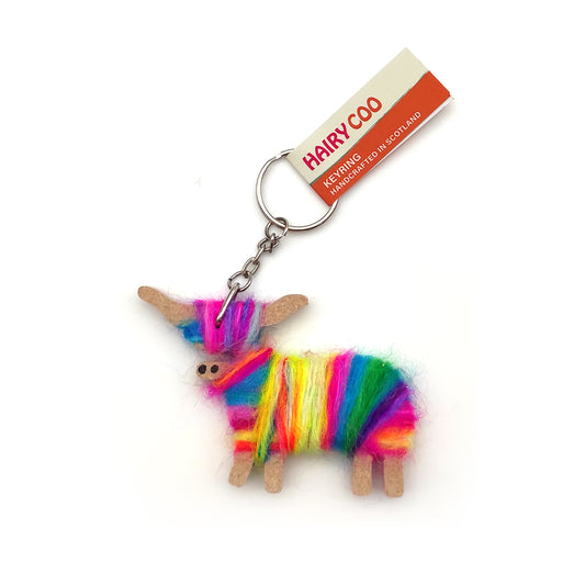 A keyring of a highland cow made of wool and wood. The wool has a rainbow of colours and is set against a plain white background.