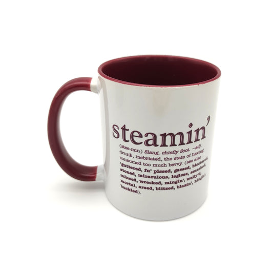 White mug with a maroon inside and handle against a plain white background. The mug is printed with the word steamin' and its definition in maroon.