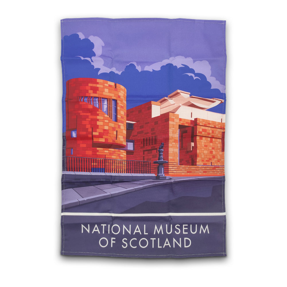 A printed tea towel with an illustration of the National Museum of Scotland with Greyfriars Bobby in the foreground. The words National Museum of Scotland are in a large sans serif font in white along the bottom.