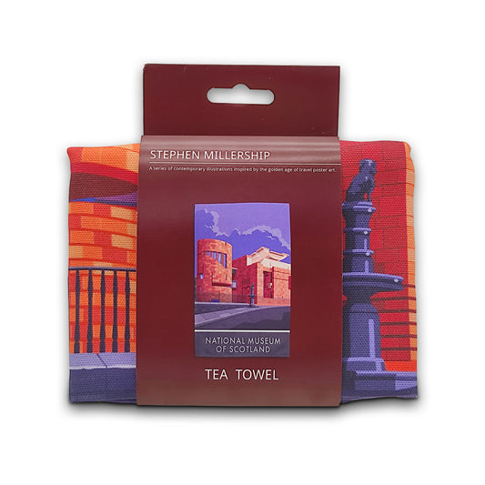 A folded printed tea towel in a maroon cardboard sleeve against a plain white background.