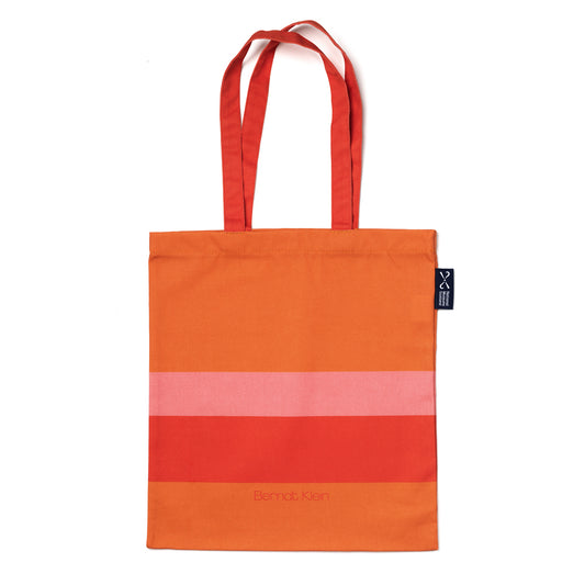 An orange and pink striped cotton shopping bag based on Bernat Klein's work against a plain white background.