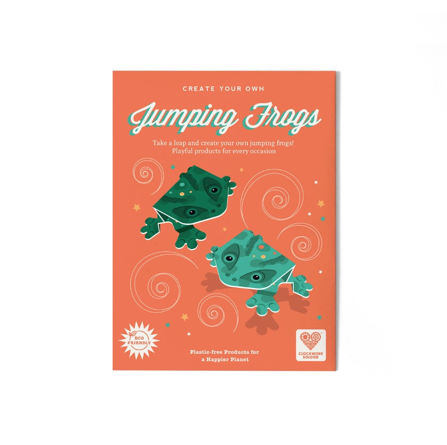 Packaging for some foldable paper jumping frogs. Two green frogs are shown jumping against the orange packaging background.