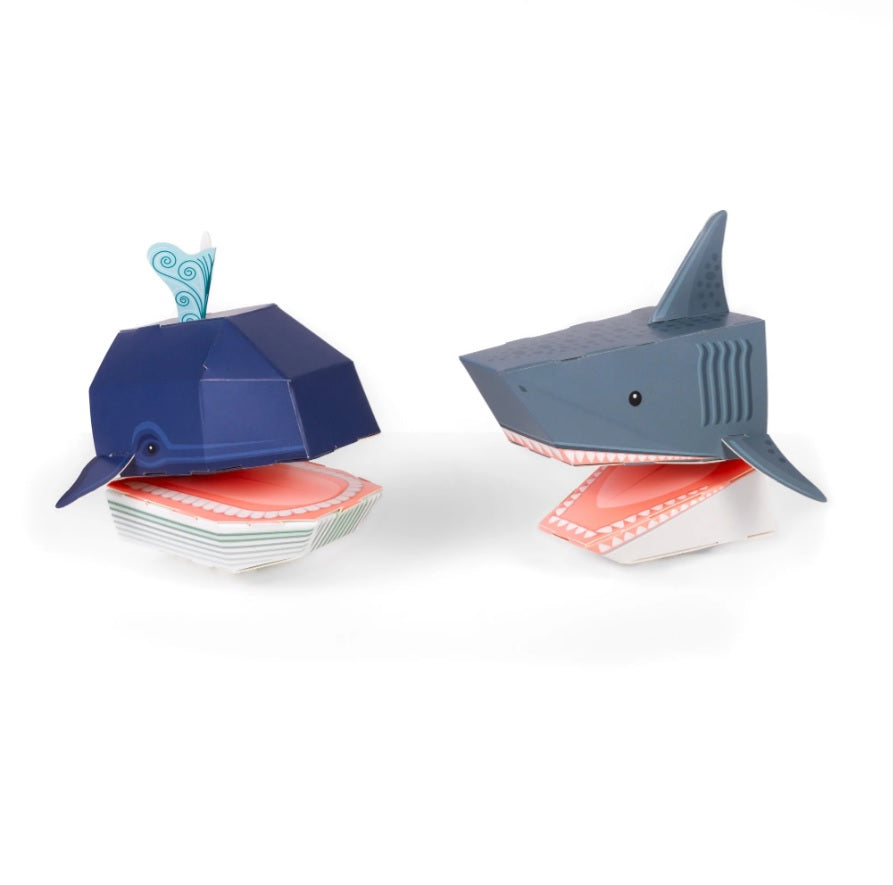 A whale and a shark folded paper hand puppet against a white background.
