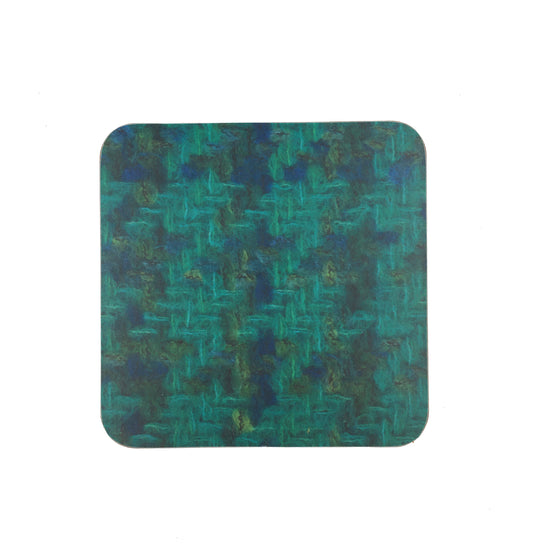 A square coaster with a photograph of the Bernat Klein fabric "Balaton". The fabric is woven in greens and blues.