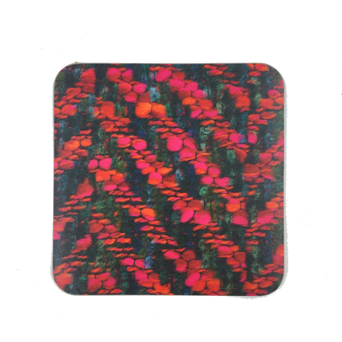 A square coaster with a photograph of the Bernat Klein fabric "Venice". The fabric is woven in reds, greens, and black.