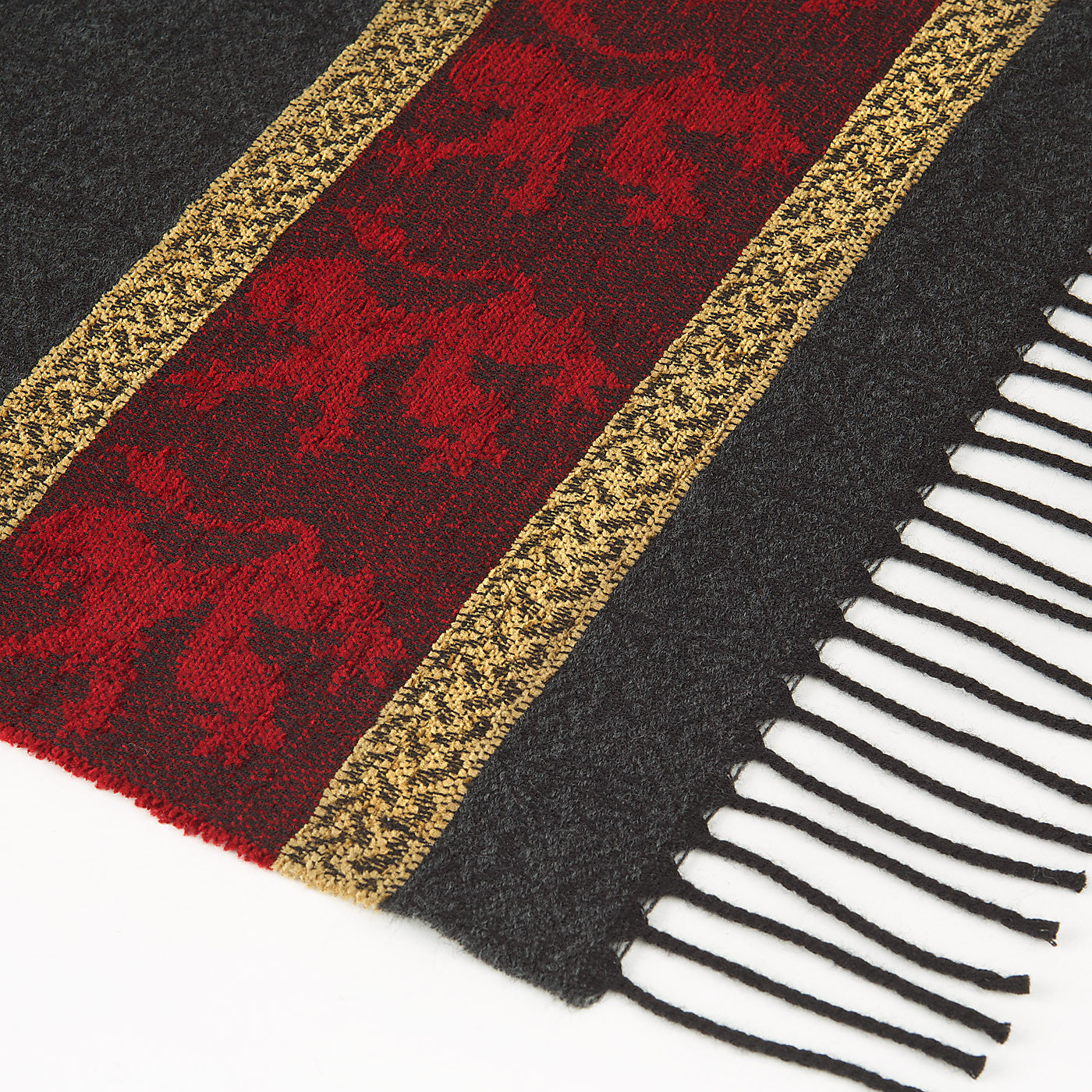 Dark grey and red tassled scarf detail with a celtic knot and lion pattern against a plain white background.