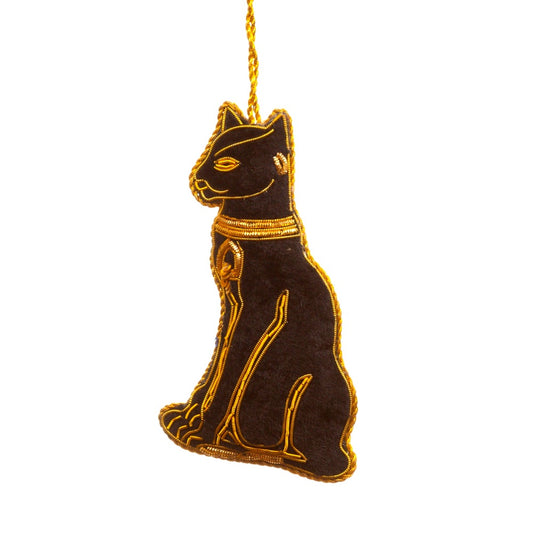 An embroidered hanging decoration of an Egyptian cat. The decoration is made form a black fabric and embroidered with gold detailing.
