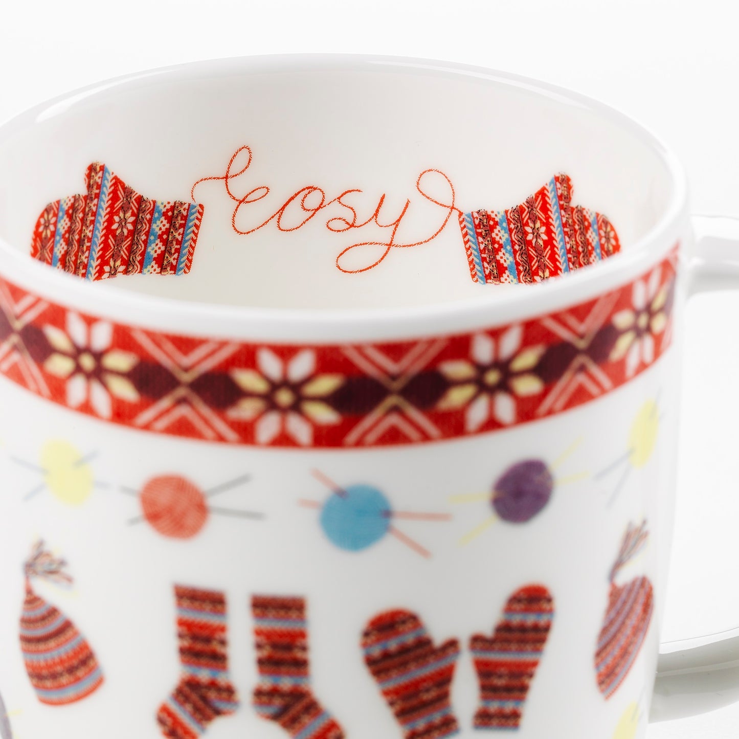 A bone china mug with a knitted fair isle inspired illustrated design. Some illustrated mittens and the word cosy are printed on the inside.